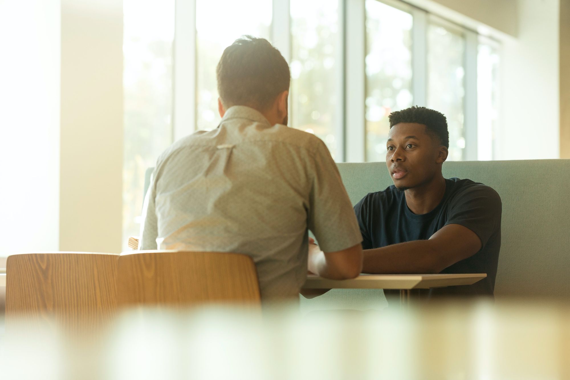 Two Young Men Look at Laptop